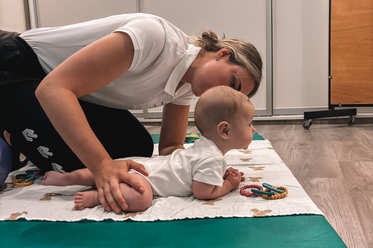 Kinderfysiotherapie bij PMC Hoek van Holland: kinderfysiotherapeut begeleidt baby tijdens motorische oefening